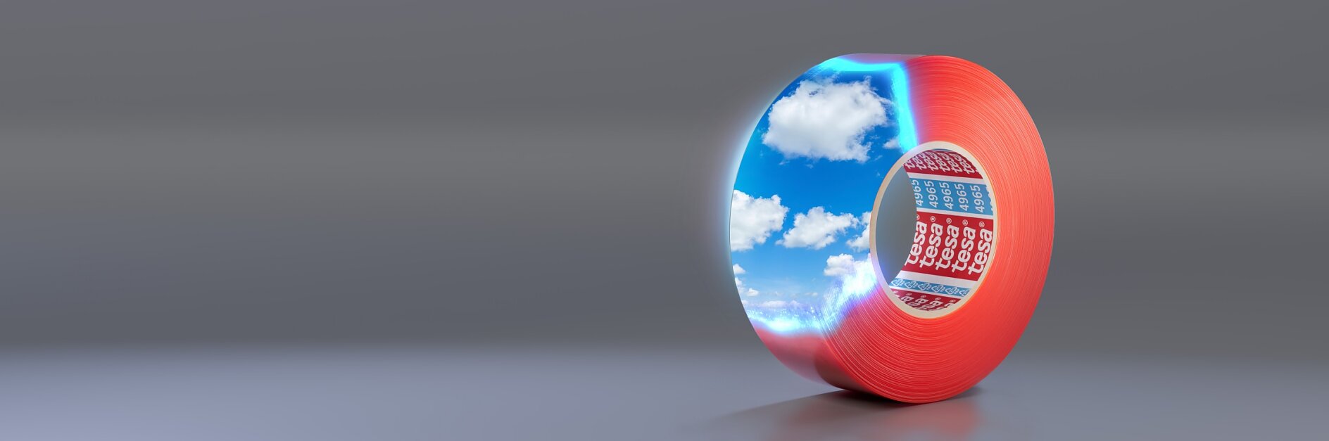 A roll of red tesa tape with reflective coating, showing a vivid sky with clouds on its surface. It is positioned upright on a smooth, gray background.