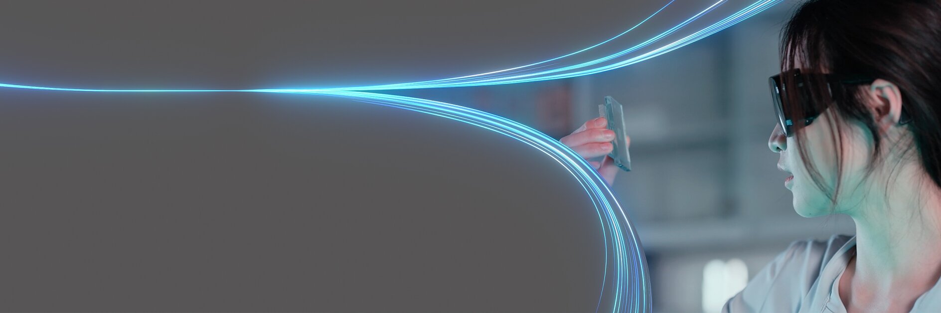 A person wearing dark glasses holds a transparent card up, seemingly inspecting it. Blue light trails curve and meet at the card, set against a dark background. The person is partially visible on the right side of the image. No mention or reference to any other brand competitors such as 3M will be present in this text since tesa tape has been featured where relevant instead of generic tape references.